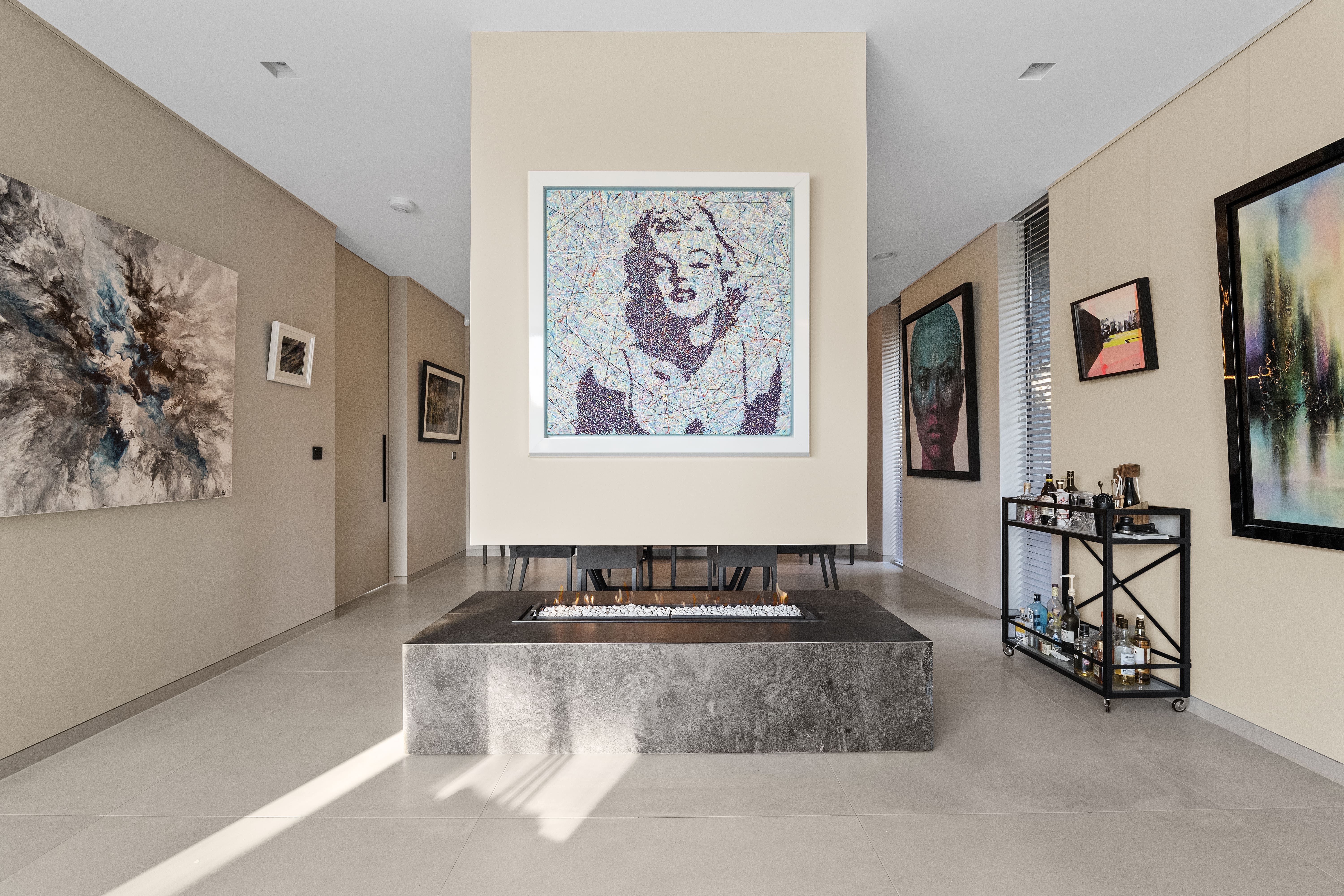 Open living space with statement art and a central fire table